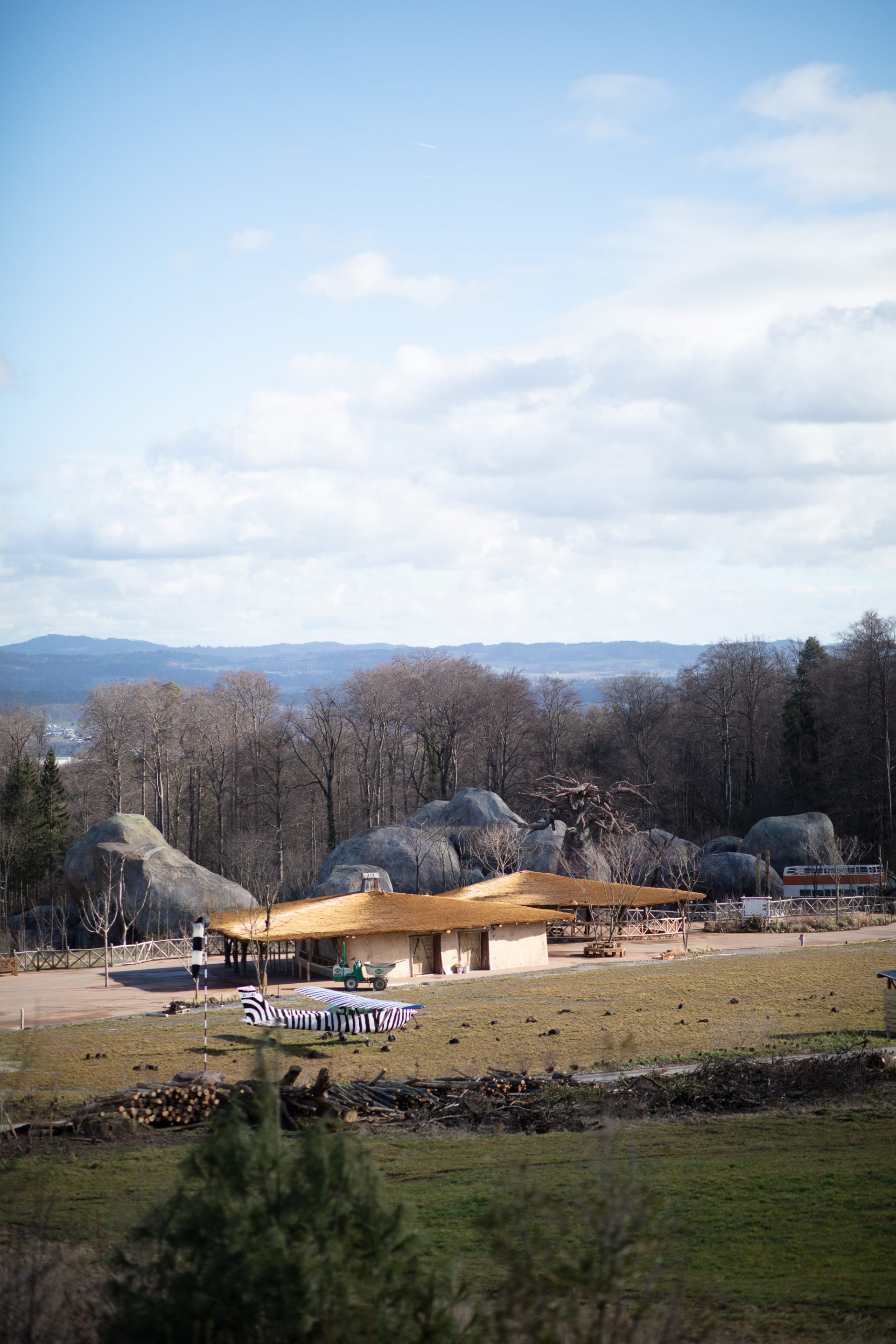 Vor einer Hütte der Lewa-Savanne steht ein mit Zebra-Muster bemaltes Ein-Passagier-Flugzeug