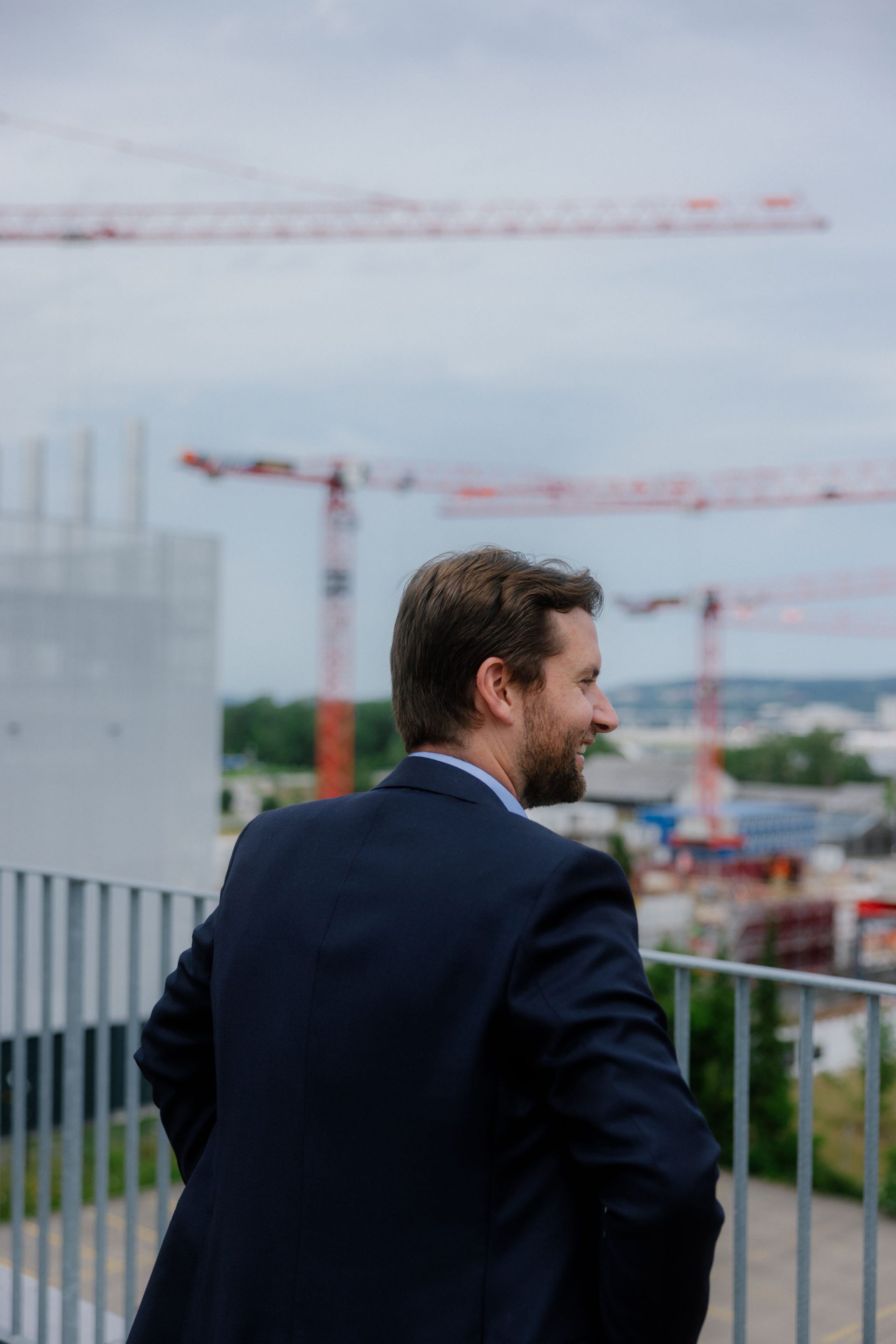 Porträt von Roman Leiser, hinter ihm Ausblick auf die Baustelle des Interxion ZUR3
