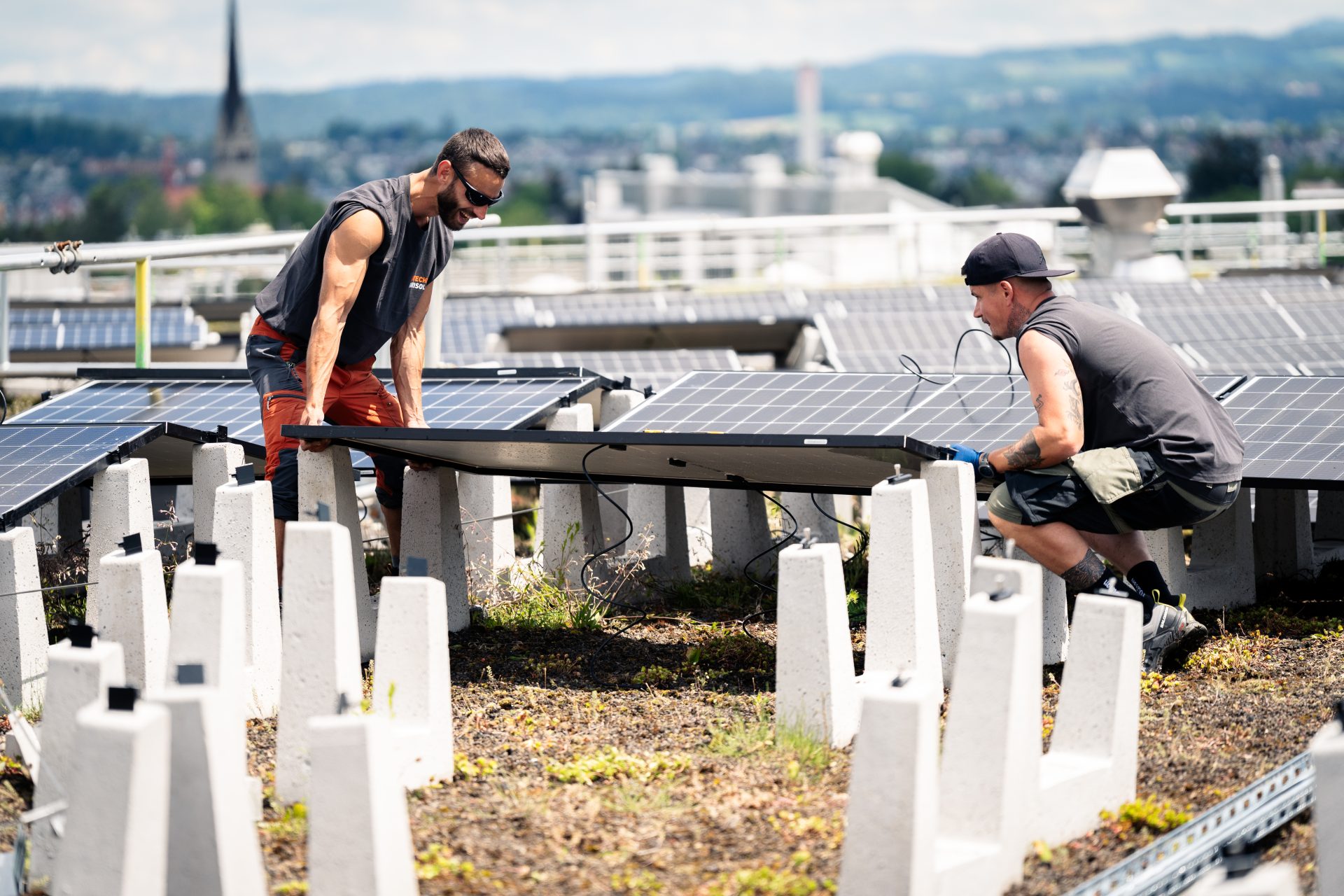 Arbeiter montieren Solaranlagen auf der Überbauung Guggach in Zürich.
