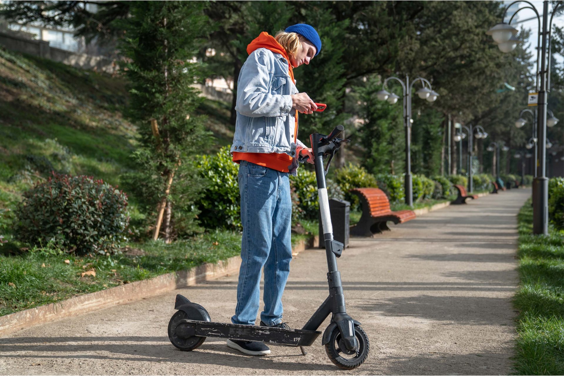 Jugendlicher mit E-Scooter im Park – modernes Elektrofahrzeug für Jugendliche ab 14 Jahren, ideal für kurze Strecken und nachhaltige Mobilität in der Stadt.