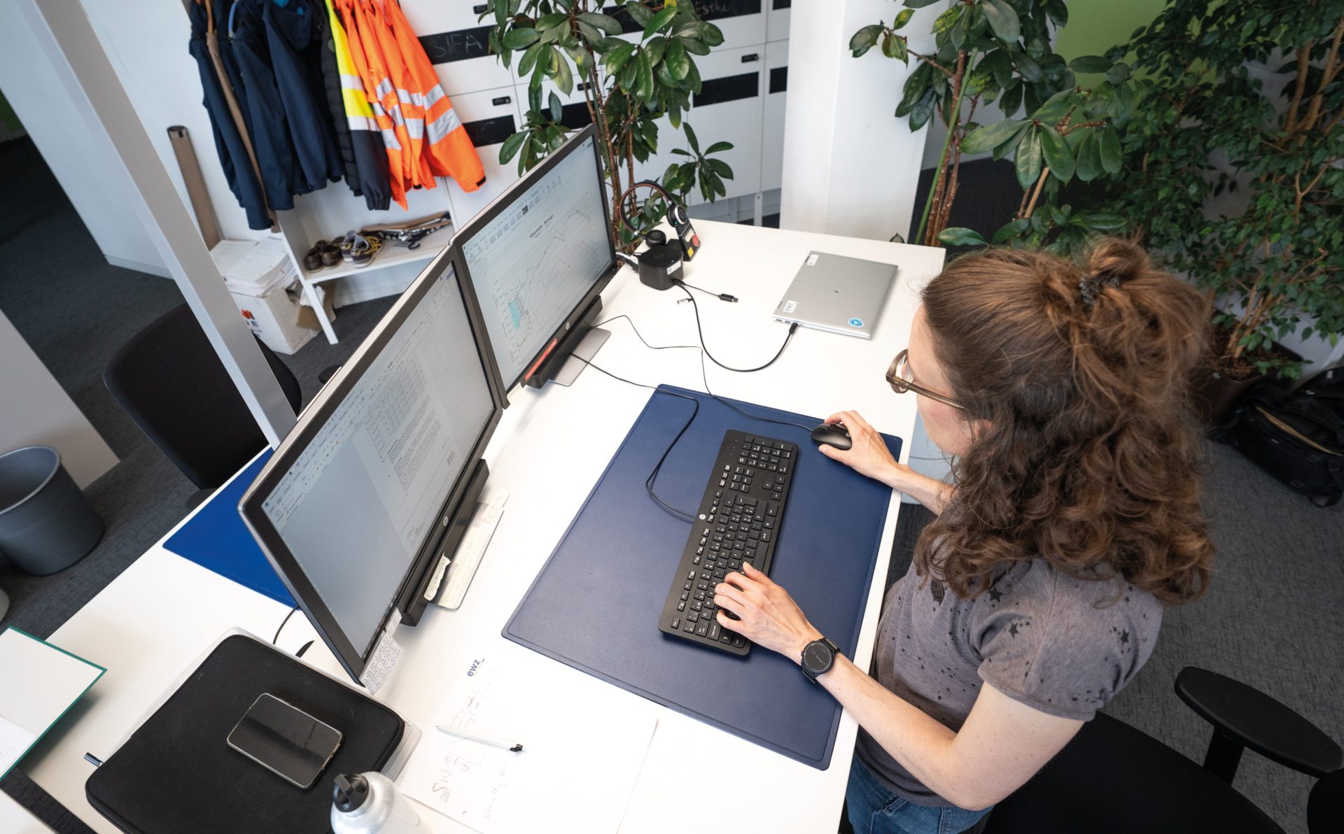 Stauanlagenüberwacherin Esther Höck überwacht an dualen Monitoren Betriebsdaten und Lastganglinien zur Sicherstellung einer stabilen und zuverlässigen Energieversorgung im Stromnetz.