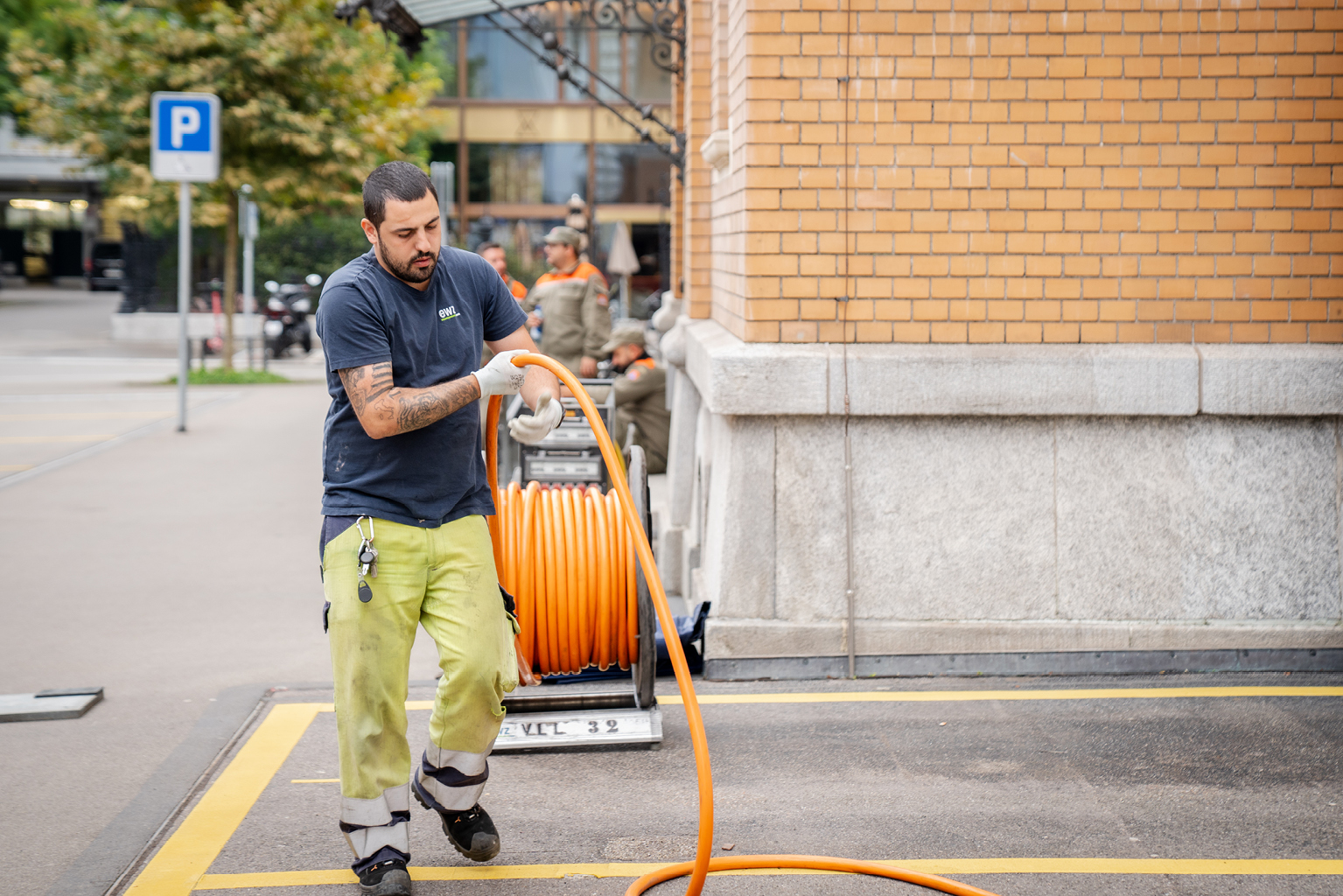 ewz-Mitarbeiter verlegt orange Kabel in der Zürcher Innenstadt – zuverlässige Arbeiten für stabile Stromversorgung Zürich und schnelle Hilfe bei Stromausfall.
