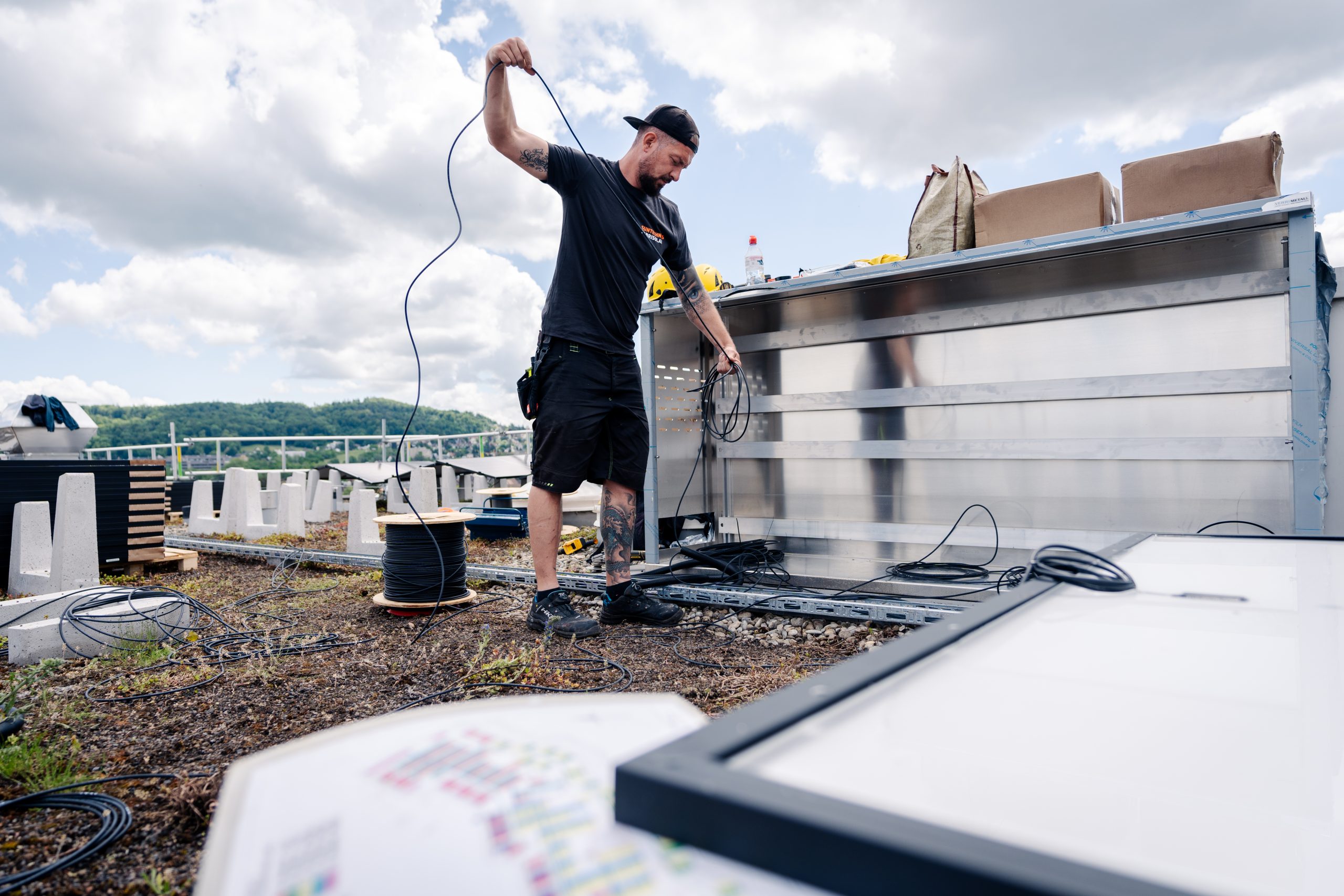 Arbeiter montieren Solaranlagen auf der Überbauung Guggach in Zürich.