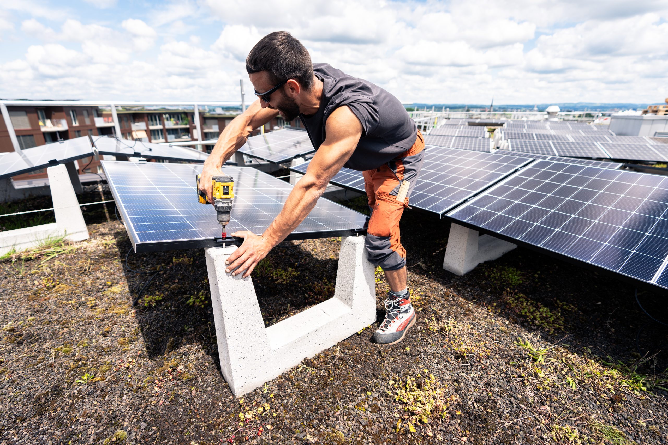 Arbeiter montieren Solaranlagen auf der Überbauung Guggach in Zürich.
