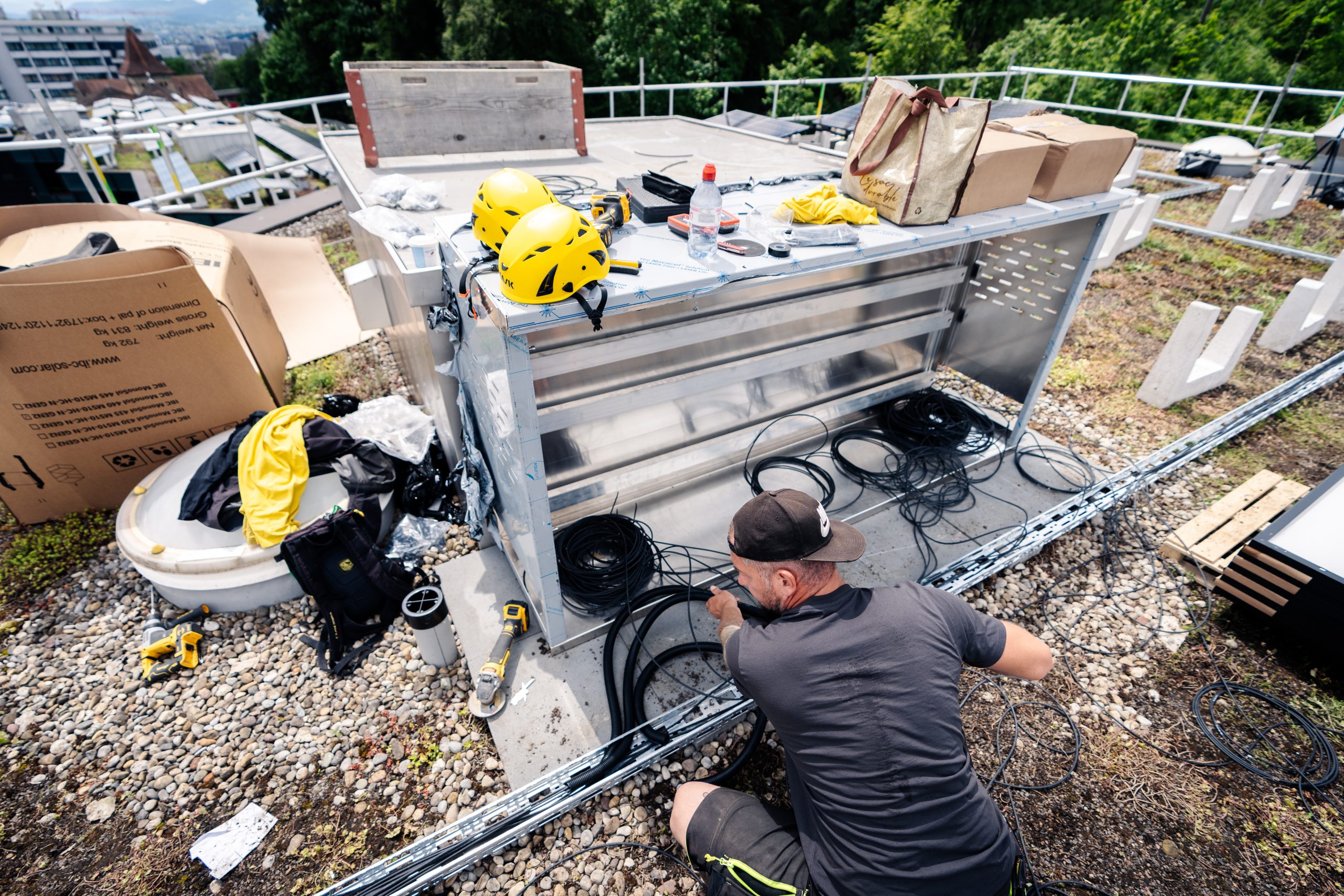 Arbeiter montieren Solaranlagen auf der Überbauung Guggach in Zürich.
