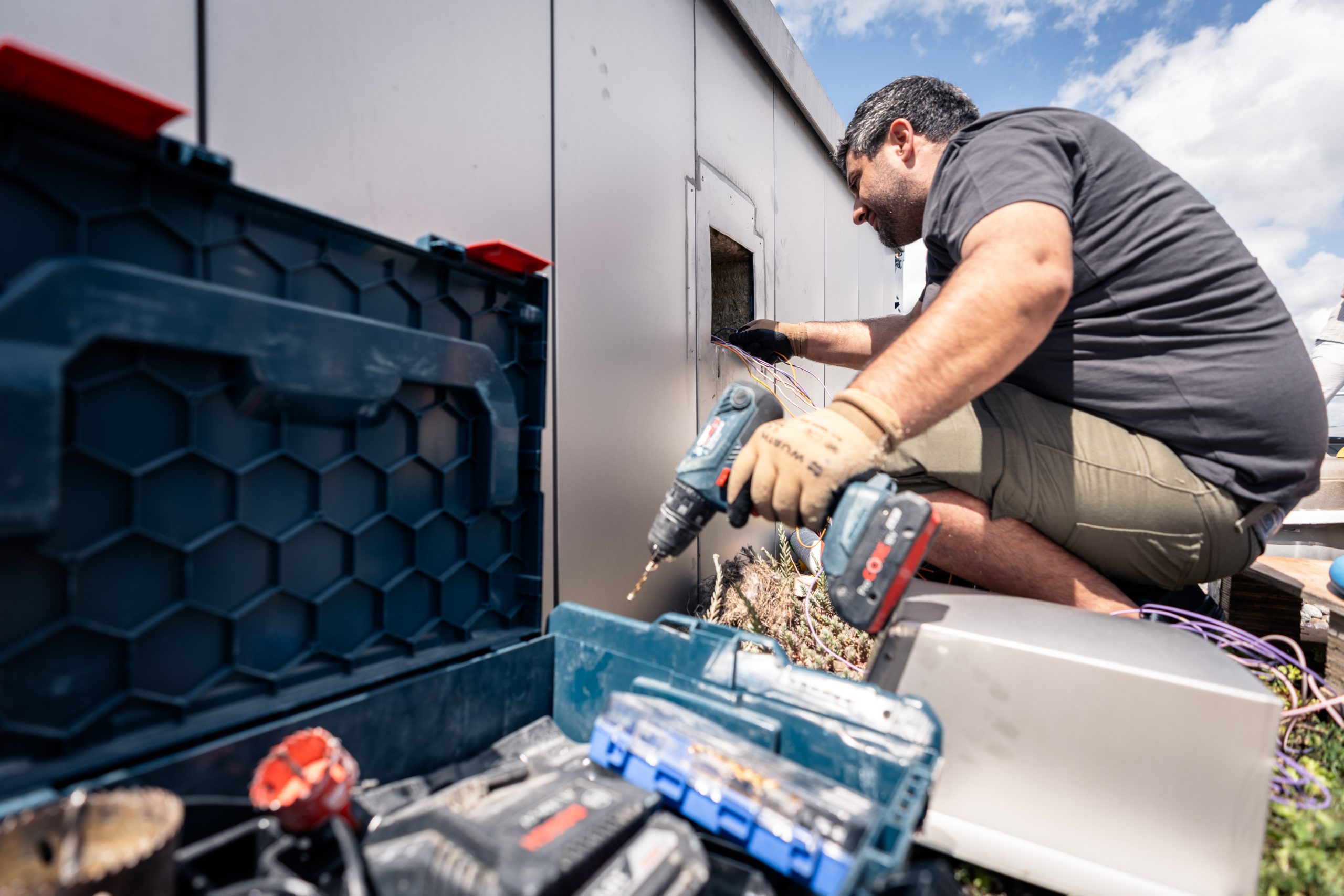 Arbeiter montieren Solaranlagen auf der Überbauung Guggach in Zürich.